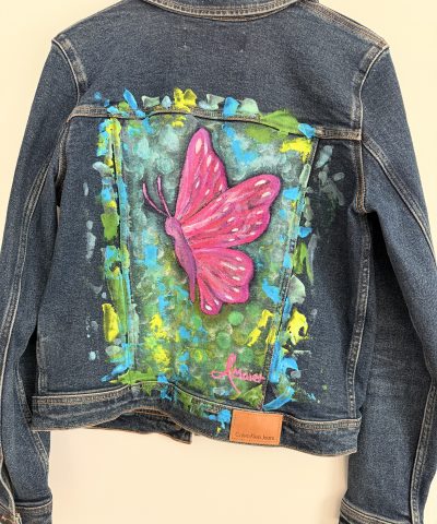 Dunkelblaue Jeansjacke mit knalligen Schmetterling