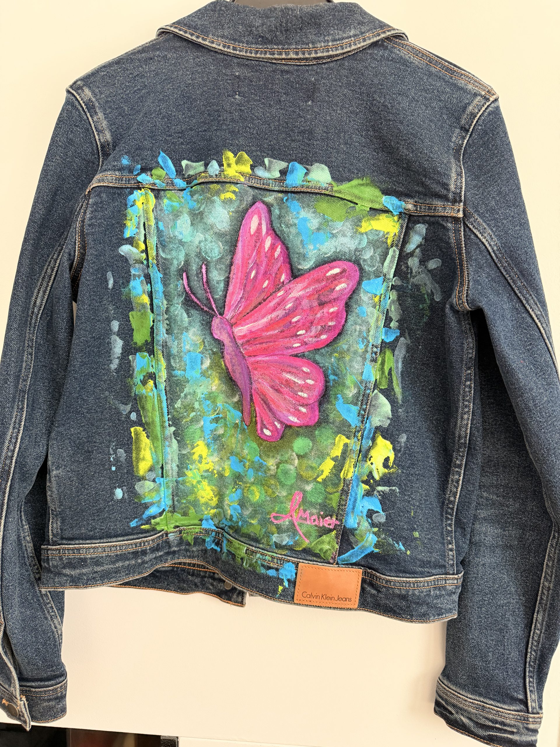 Dunkelblaue Jeansjacke mit knalligen Schmetterling